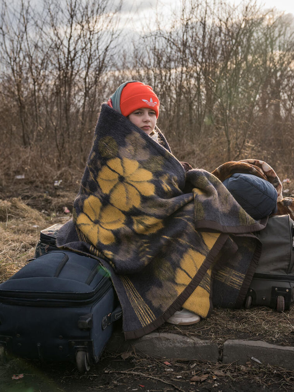 Valeria sitzt in einer Decke eingewickelt in Rumänien. 