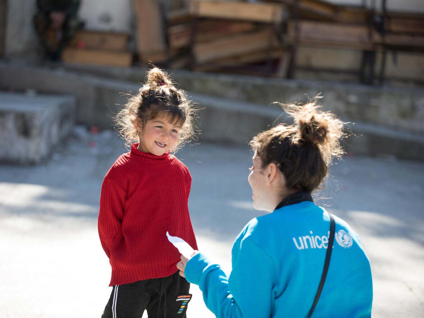 Kind aus Syrien spricht mit einer UNICEF Mitarbeiterin.