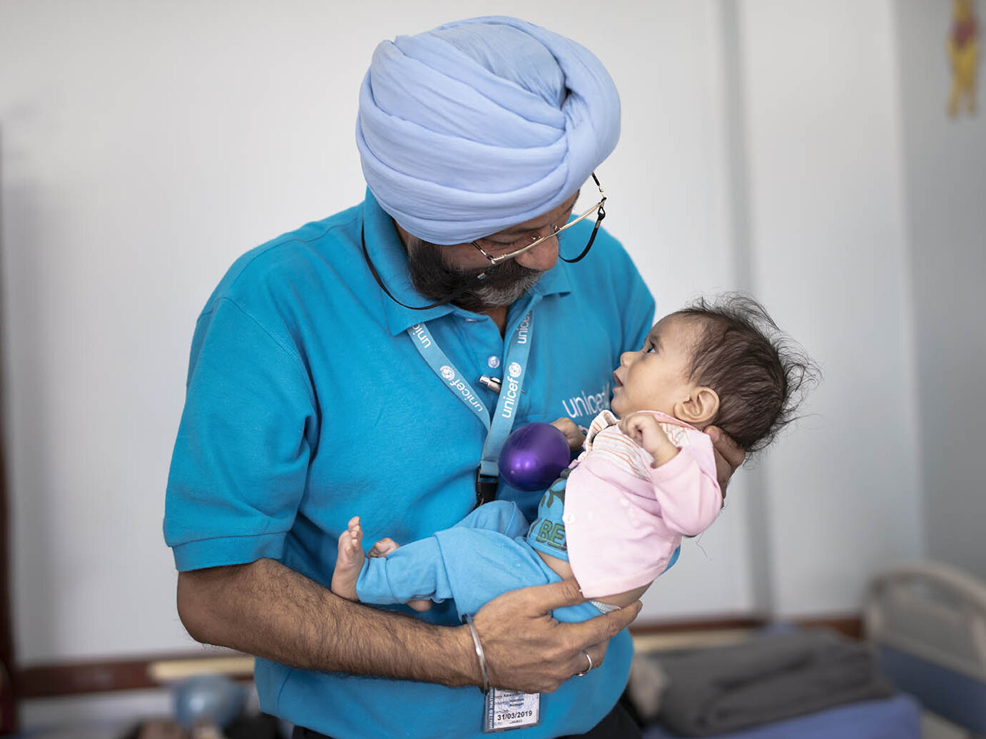 Ernährungsexperte Dr. Singh hält ein mangelernährtes Kind.