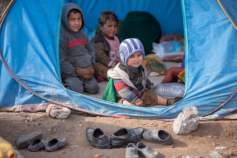 Kinder sitzen in einem Zelt in einem afghanischen Flüchtlingscamp