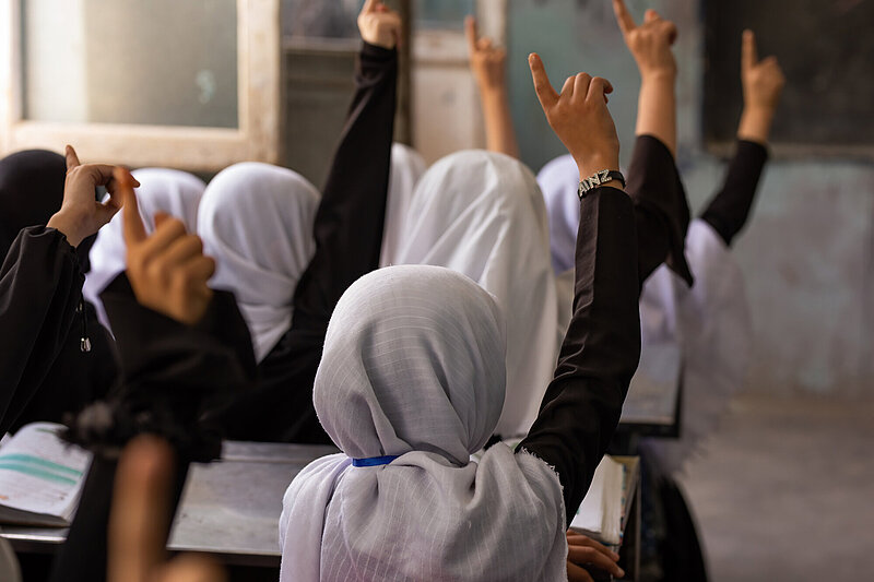 Mädchen in einer Schule in Afghanistan zeigen auf.