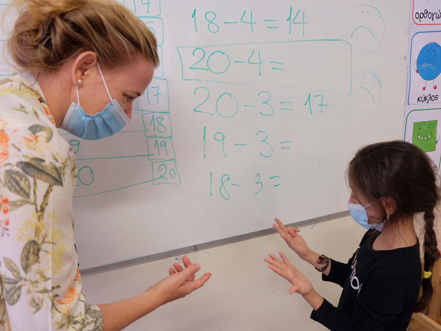 Eine Betreuerin lernt einem Kind rechnen in einem UNICEF Lernzentrum in Athen. 