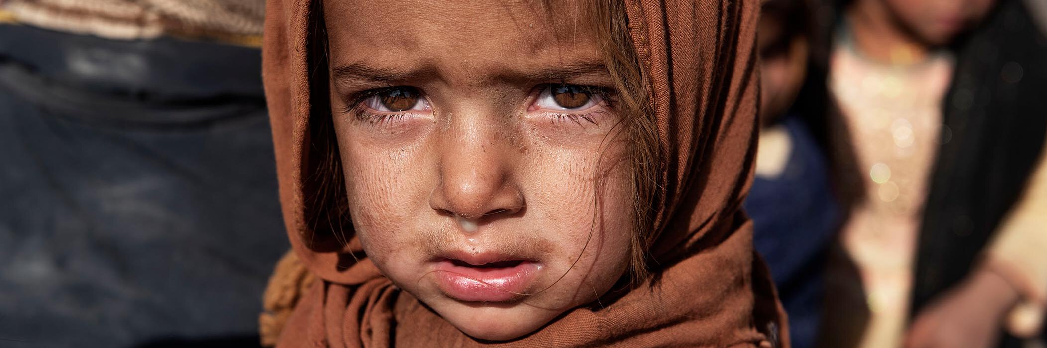 Ein afghanisches Mädchen blickt traurig in die Kamera.