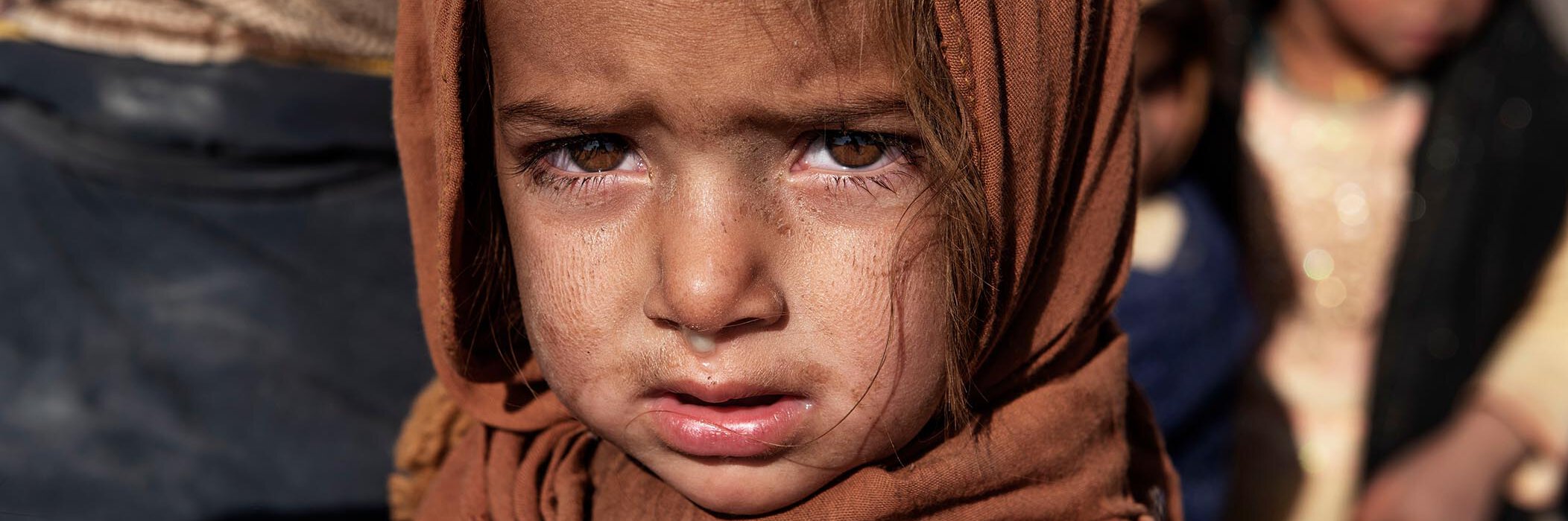 Ein afghanisches Mädchen blickt traurig in die Kamera.