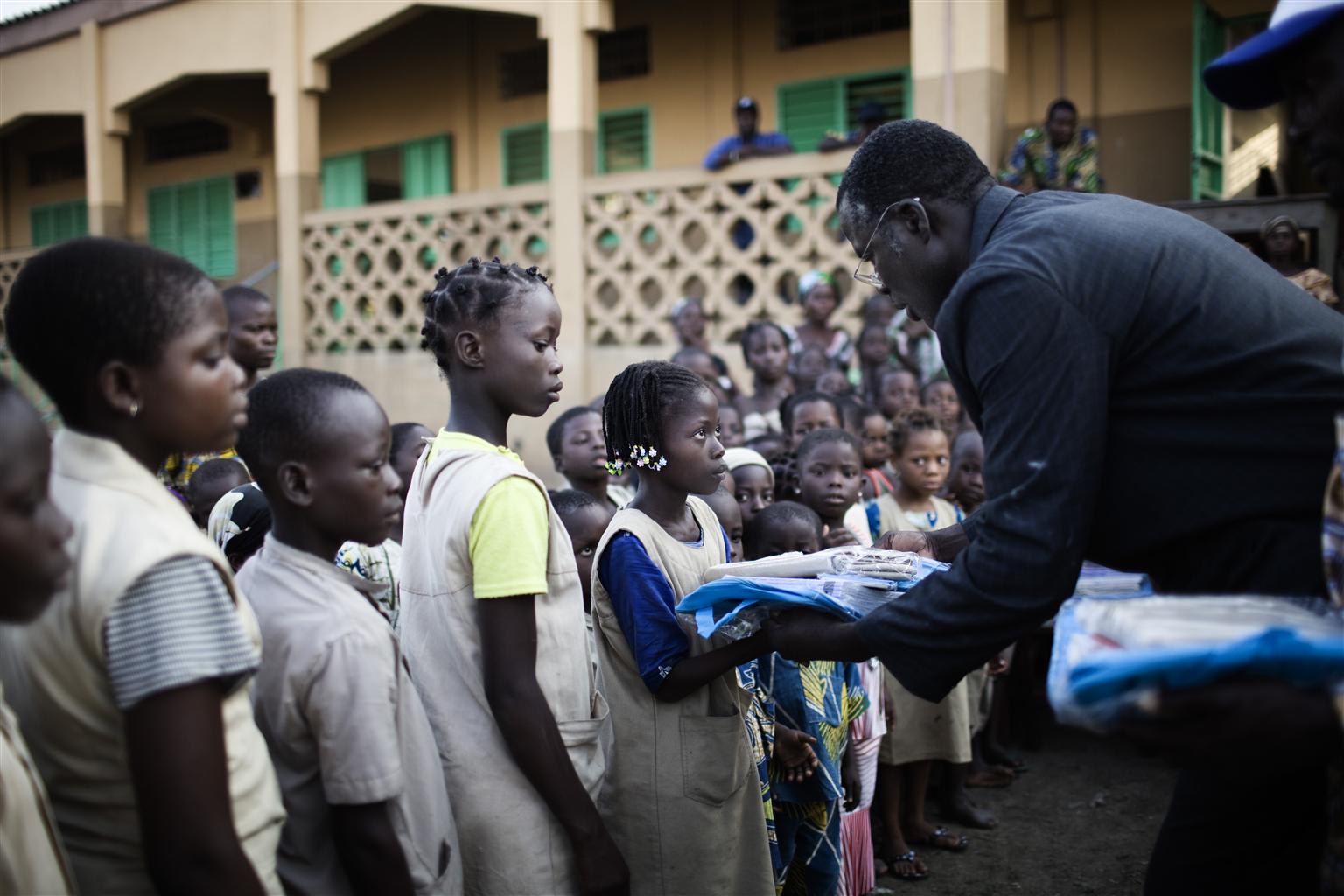 Schülerinnen bekommen ein UNICEF Schulpaket überreicht.