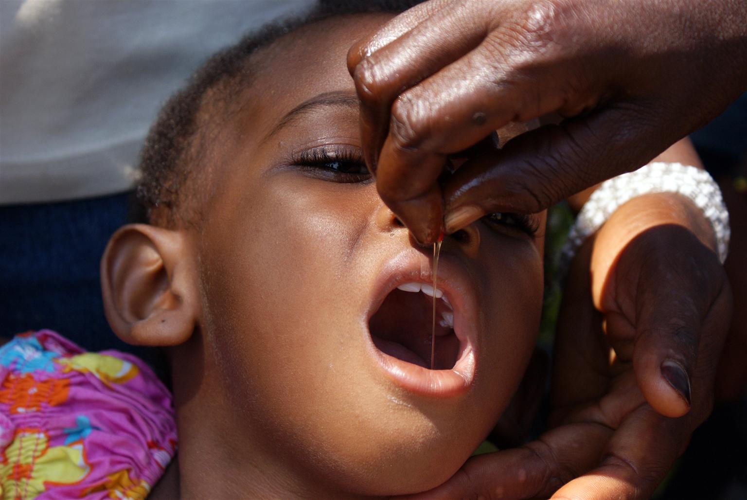 Ein achtjähriges Mädchen bekommt Vitamin A als Schluckimpfung.