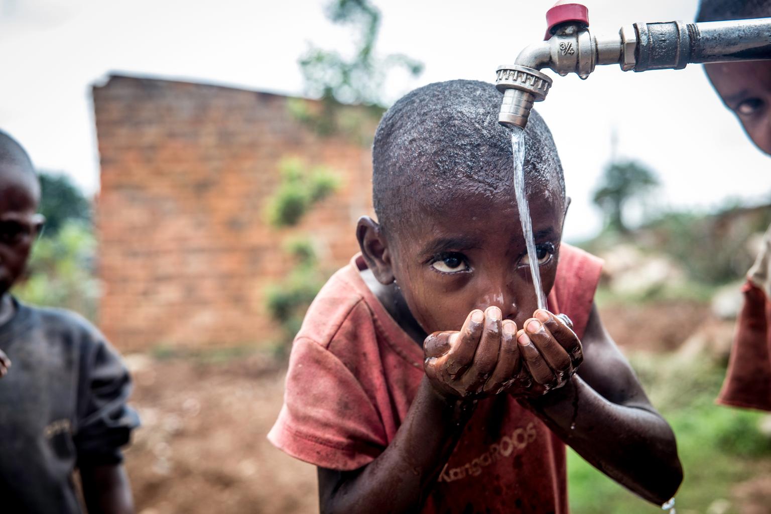 Ein Bub trinkt aus einem von UNICEF unterstützten Brunnen.