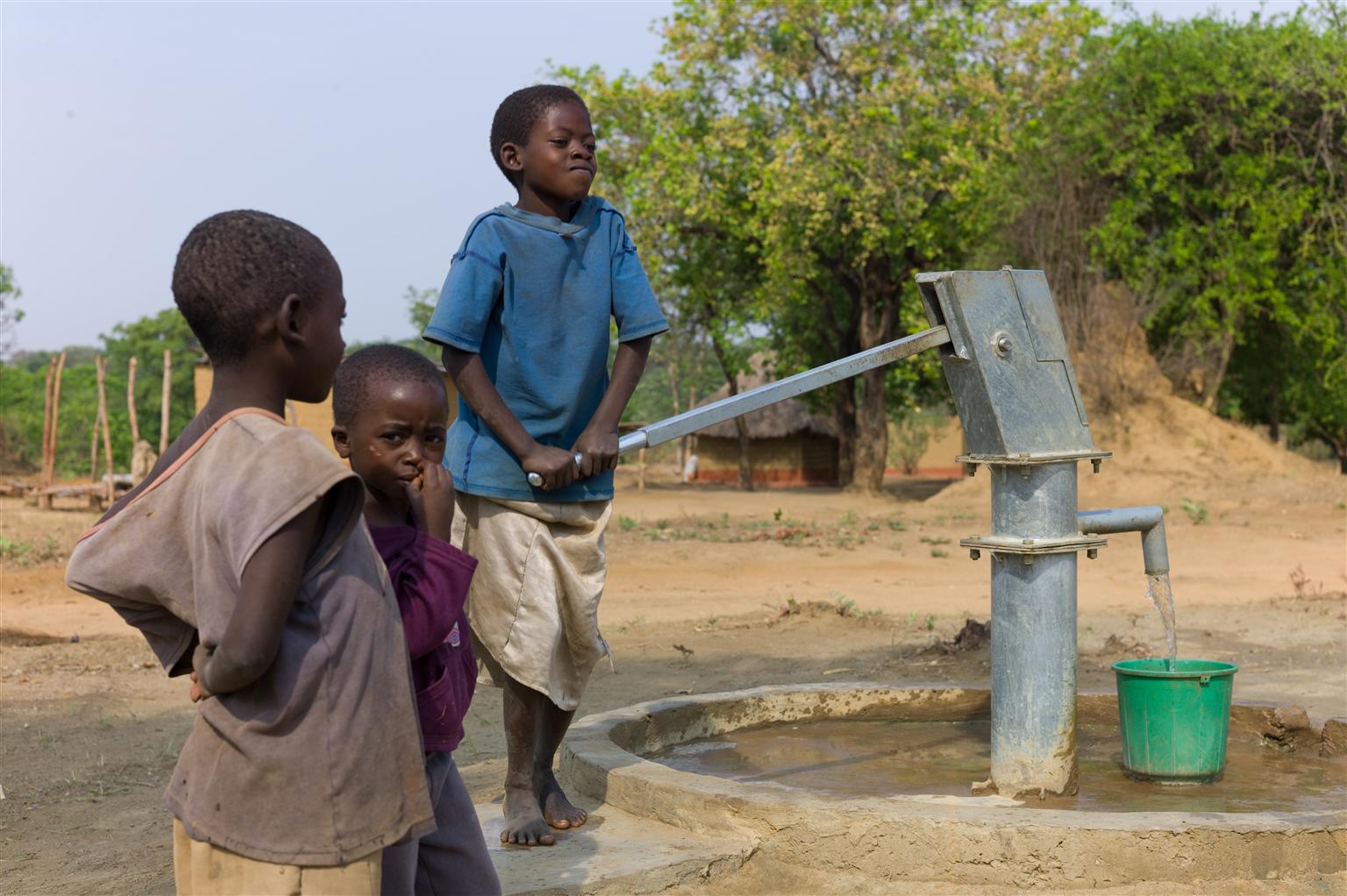 In Kampundu verwenden drei Kinder ihren neuen Brunnen.