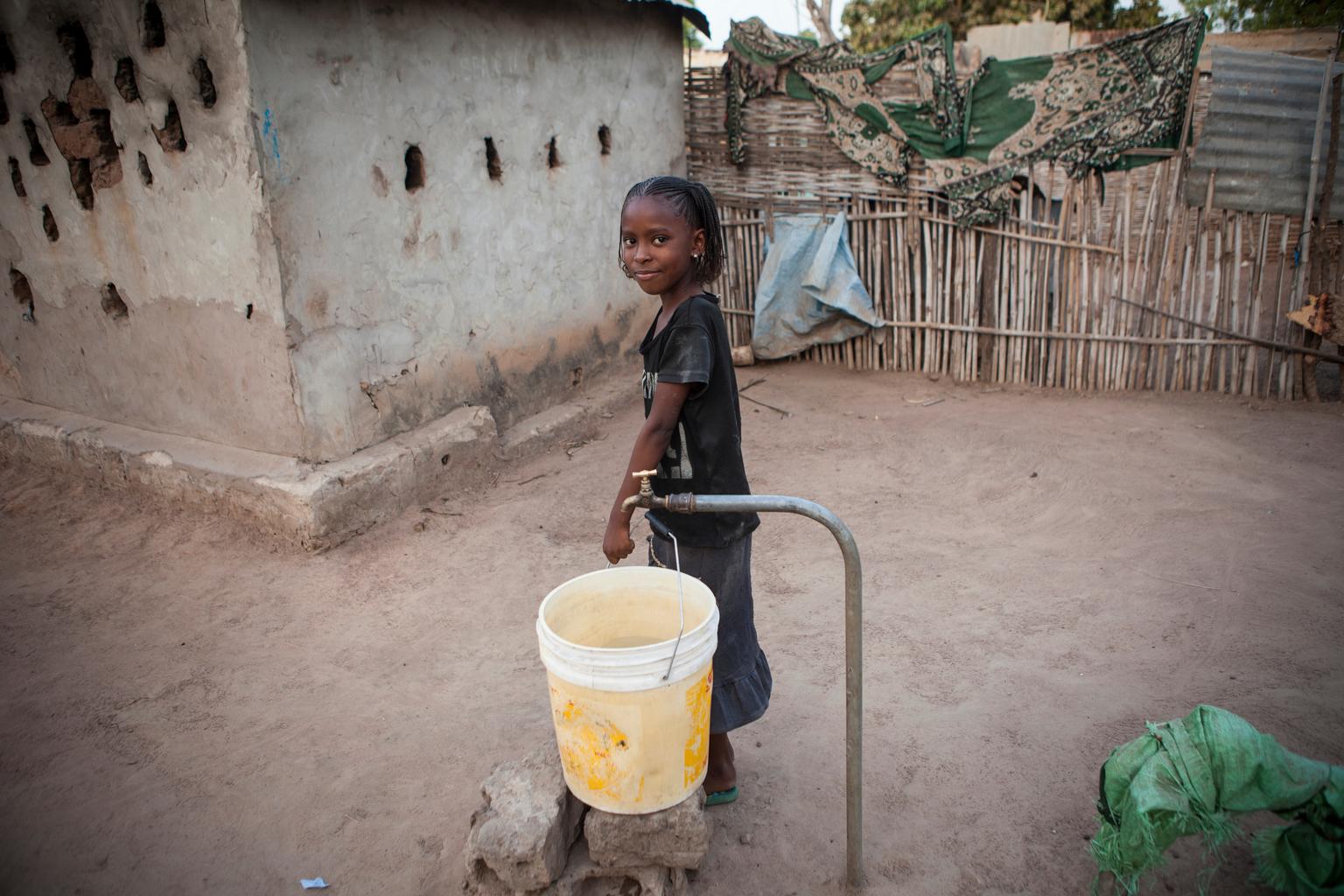 Ein Mädchen holt sich frisches Wasser aus dem neuen Brunnen in Kolda.