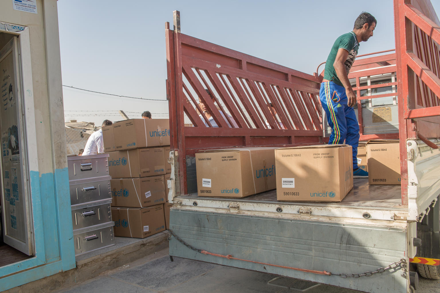 Ein freiwilliger Helfer entlädt Schulmaterialien aus einem LKW.