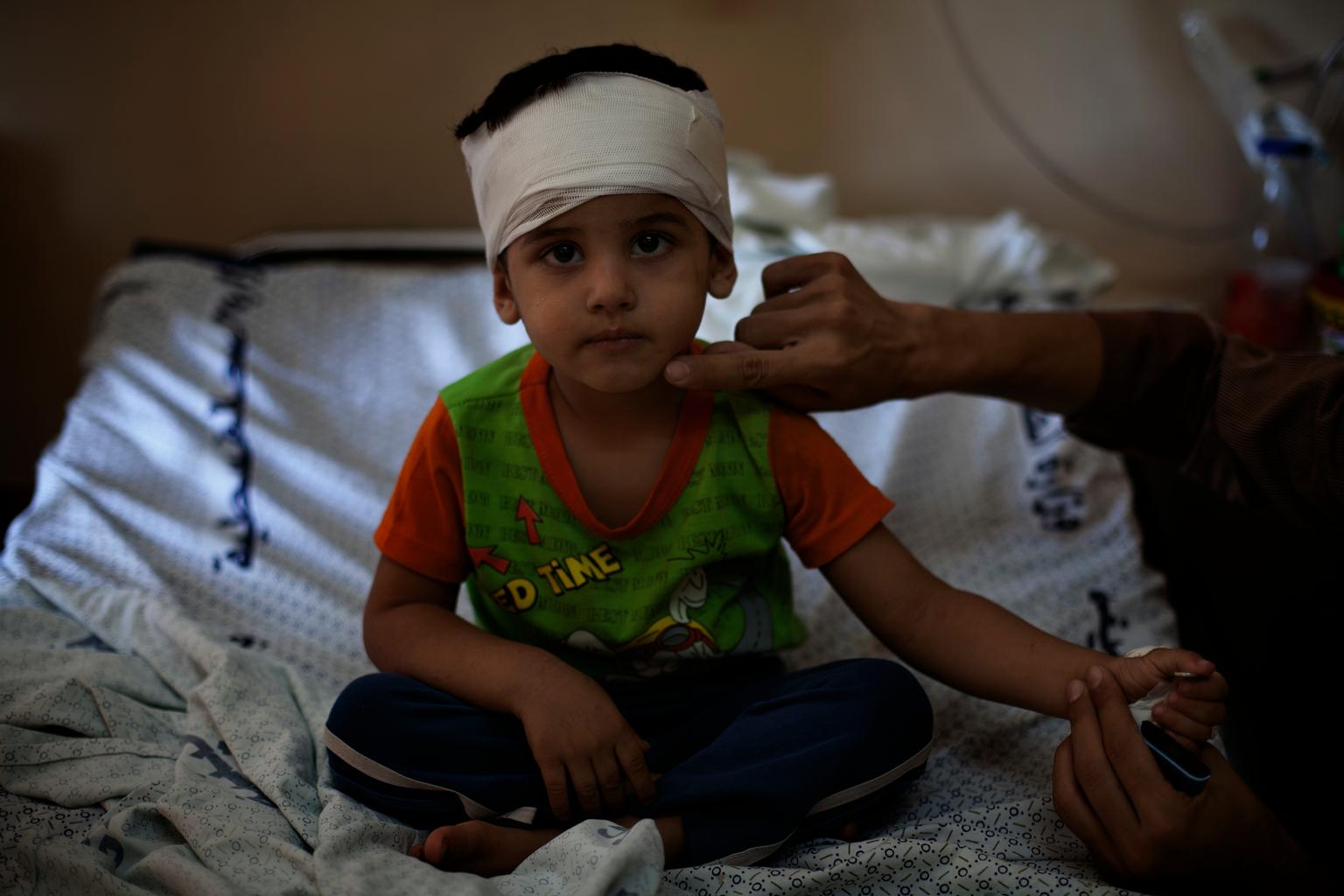 Mohammends Kopf ist bandagiert. Er sitzt auf einem Krankenbett.