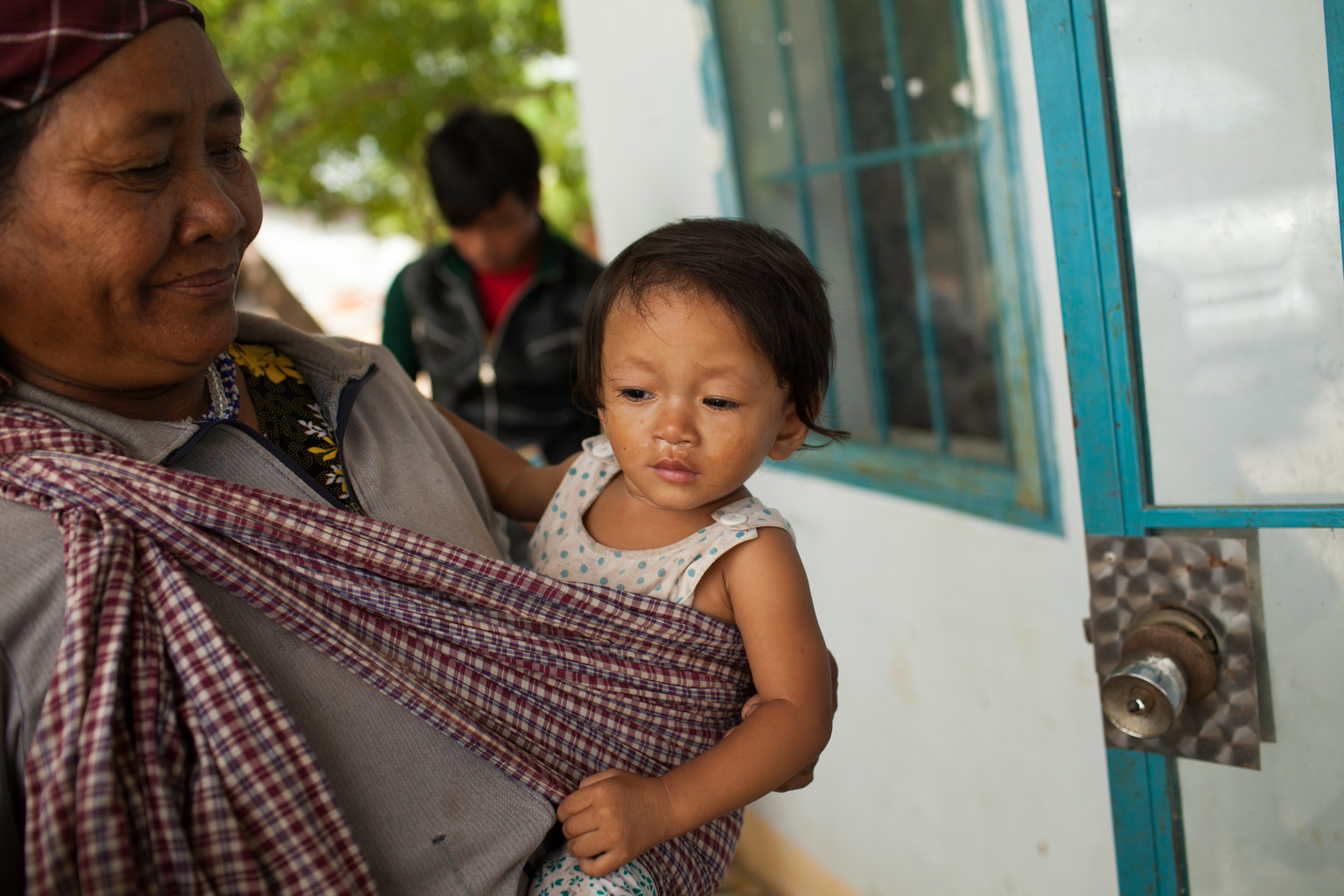 Vor dem Phuoc Thanh Gesundheitszentrum wartet eine Mutter mit ihrem Baby.