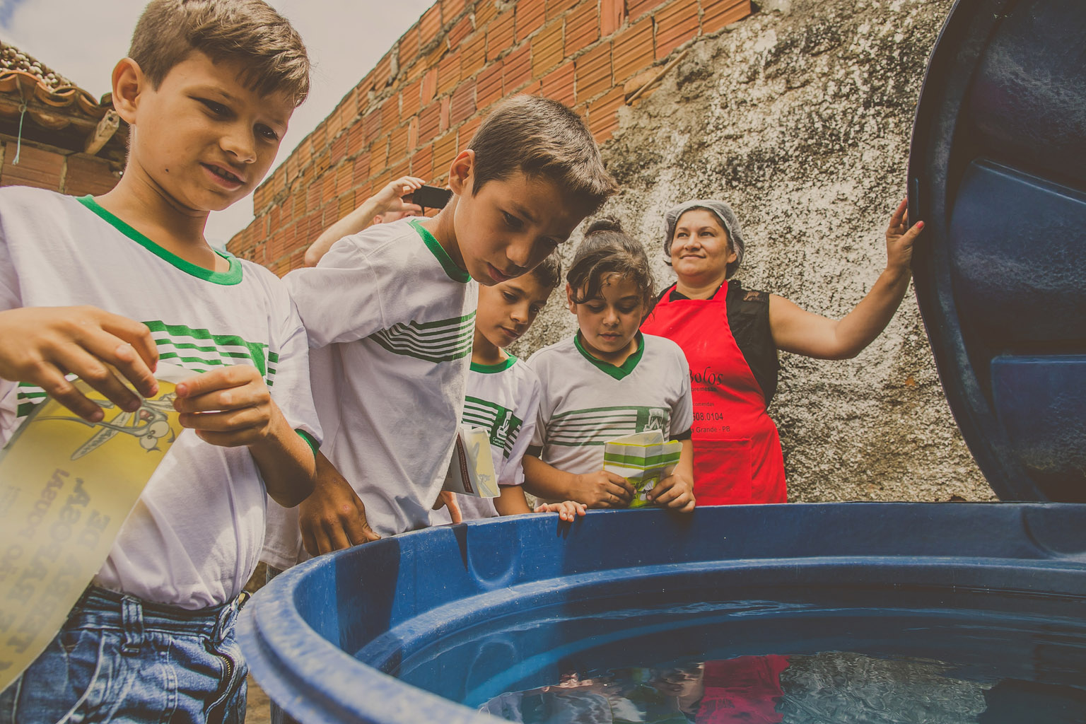 Kinder inspizieren einen Wassertank.