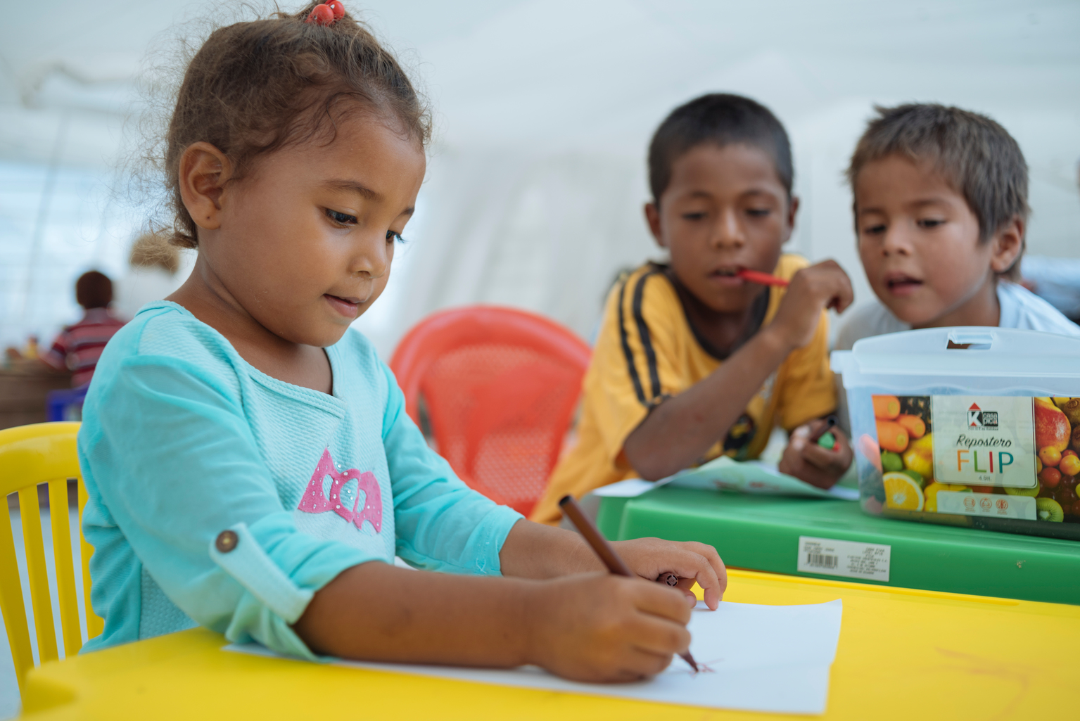 Drei Kinder zeichnen in der kinderfreundlichen Zone.