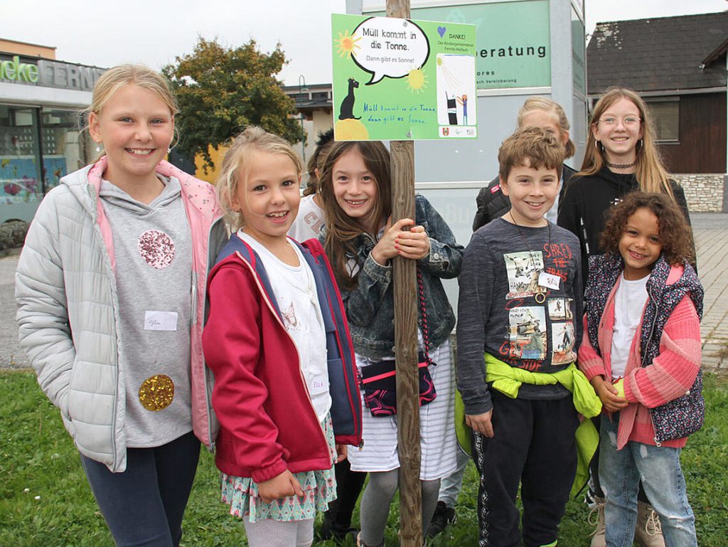 Kinder aus der Gemeinde halten ein Schild in die Höhe.