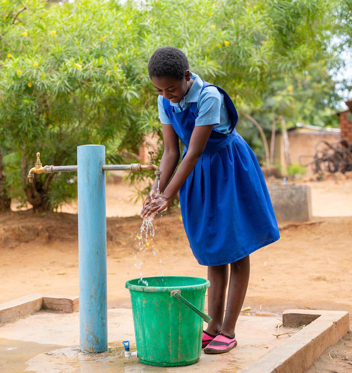 Peace aus Malawi holt sich Wasser an einer solarbetriebenen Pumpe