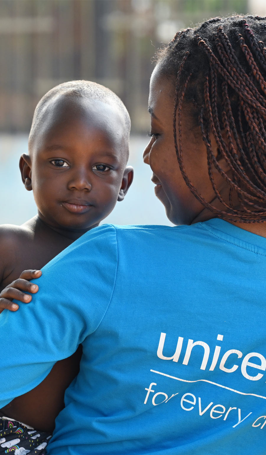 UNICEF MItarbeiterin hält Kind in den Armen