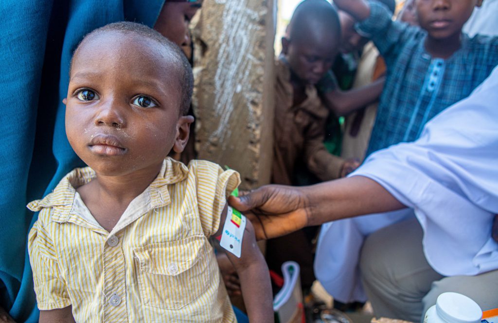 Junge aus Nigeria wird mittels Maßband auf Mangelernährung untersucht.