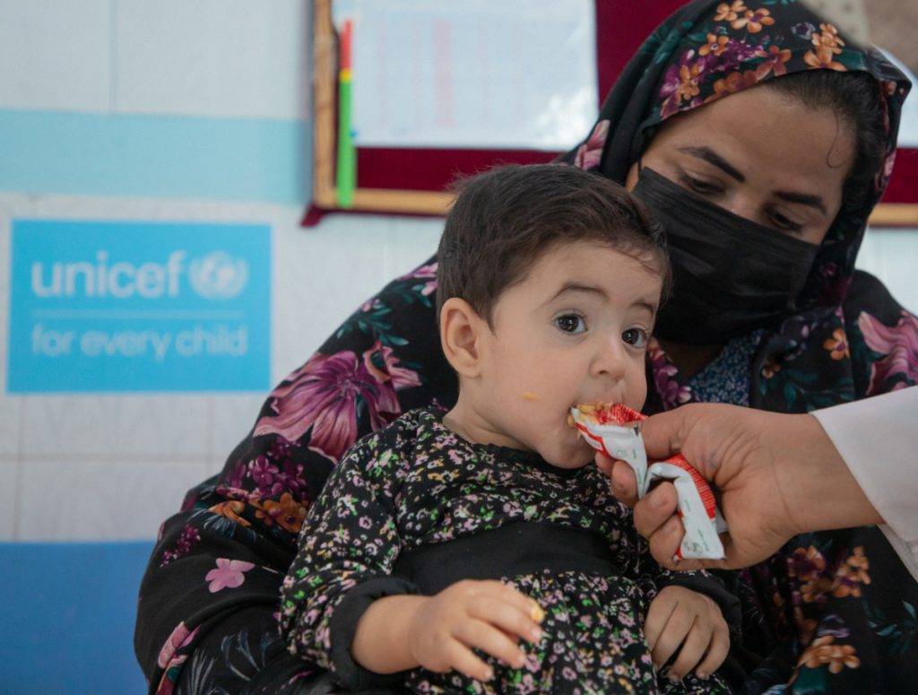 Mangelernährtes Mädchen aus Afghanistan isst Erdnusspaste.