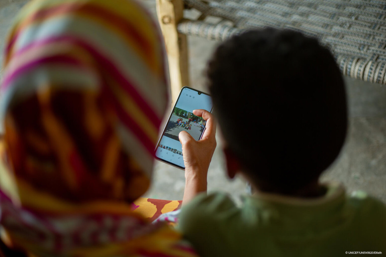 Eine Mutter zeigt ein Foto auf ihrem Handy.