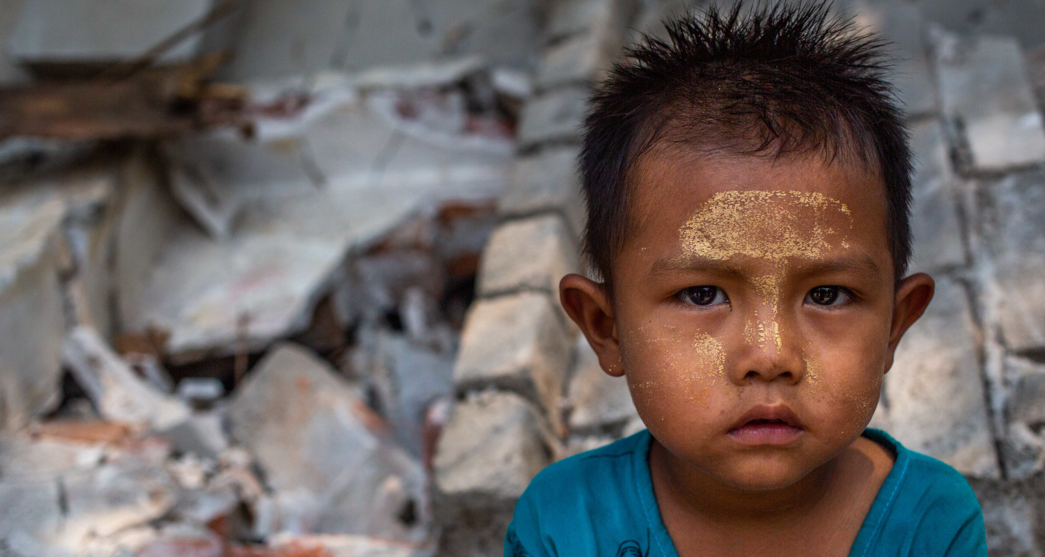 Junge sitzt in den Trümmern des Erdbeben in Myanmar.