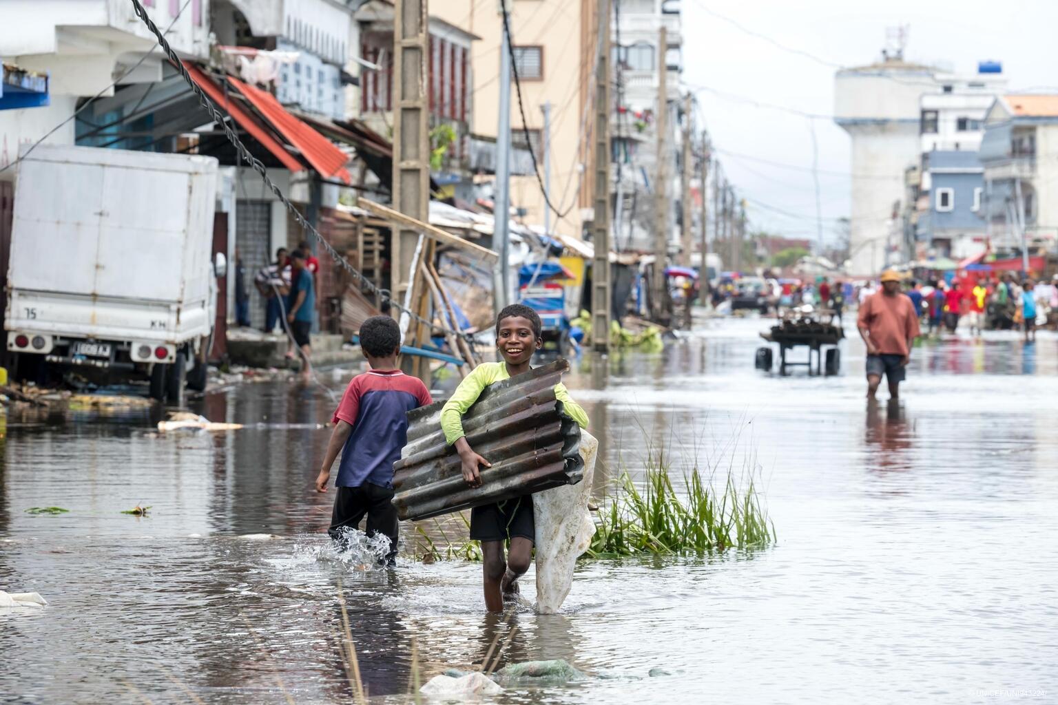Buben waten durch die vom Zyklon überfluteten Straßen Madagaskars.