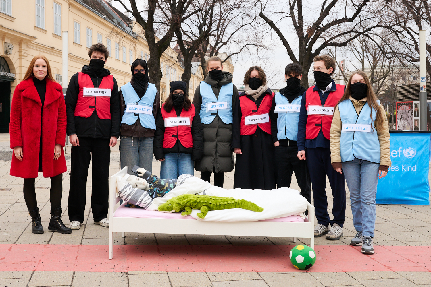 Jugendbeirat von UNICEF Österreich und Ehrenbeauftragte Barbara Meier stehen vor Kinderbett zum Saferinternet Day.