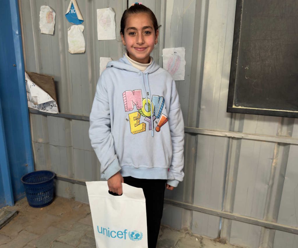 Mädchen hält einen Sack mit Lernmaterial in einer Schule in Gaza.