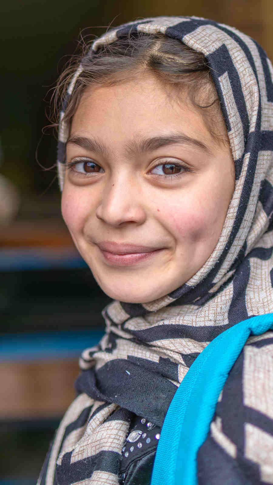 Lächelndes Mädchen mit Schultasche in Afghanistan.