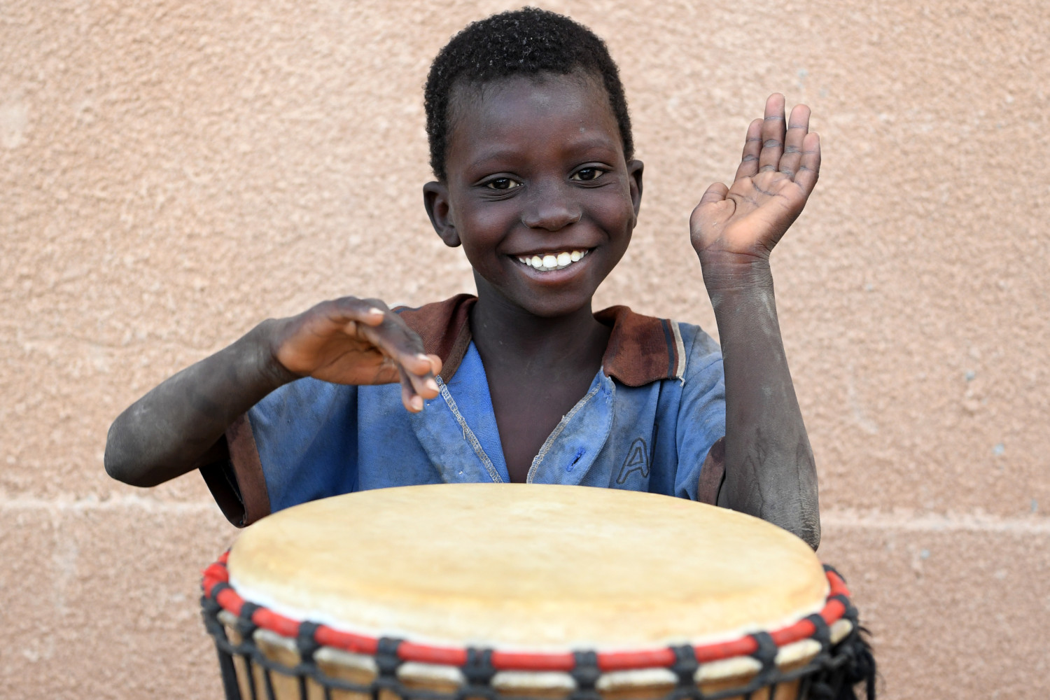 Junge spielt Trommel in Niger.