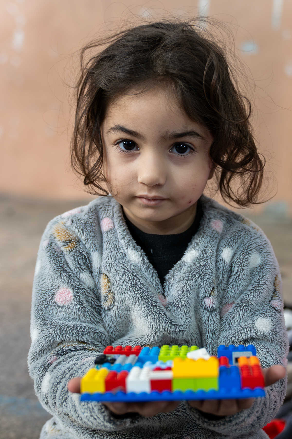 Mädchen hält Lego in einem Flüchtlingscamp im Libanon.