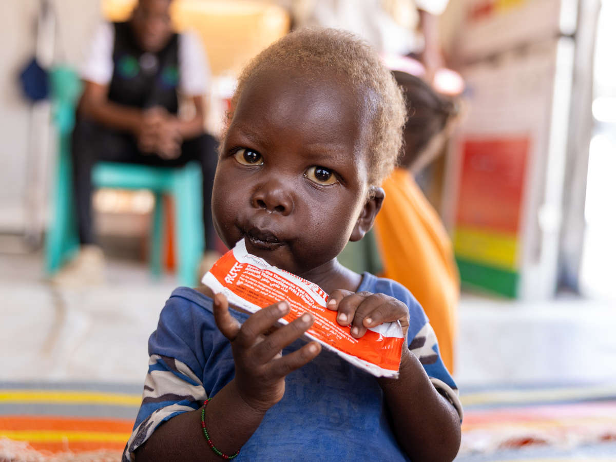 Mangelernährter Junge in einem Lager für Geflüchtete im Sudan isst Erdnusspaste.