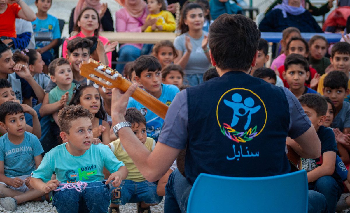 Mann spielt Gitarre in einem Musikprogramm für Kinder in Syrien.