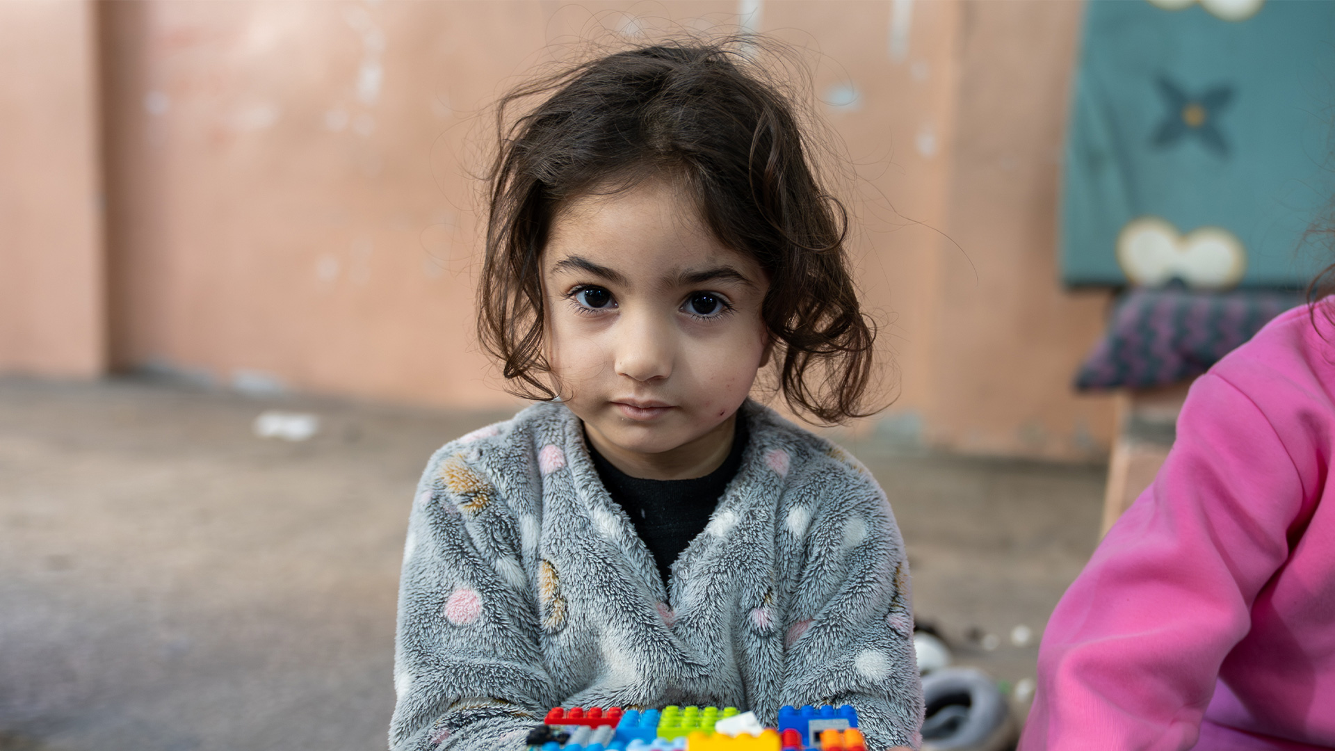 Mädchen hält Lego in einem Flüchtlingscamp im Libanon.