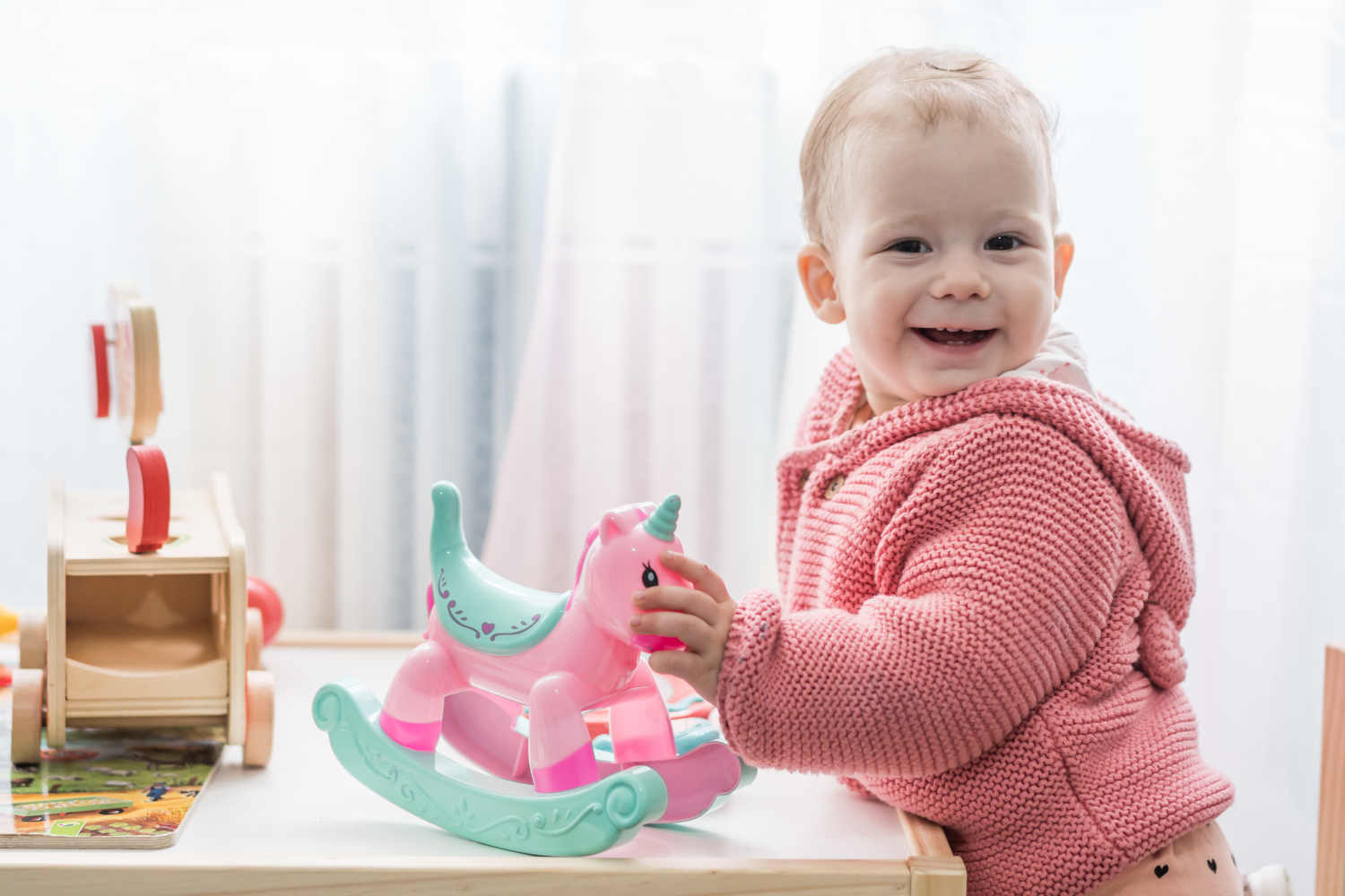 Lächelndes Kleinkind mit Spielzeug.