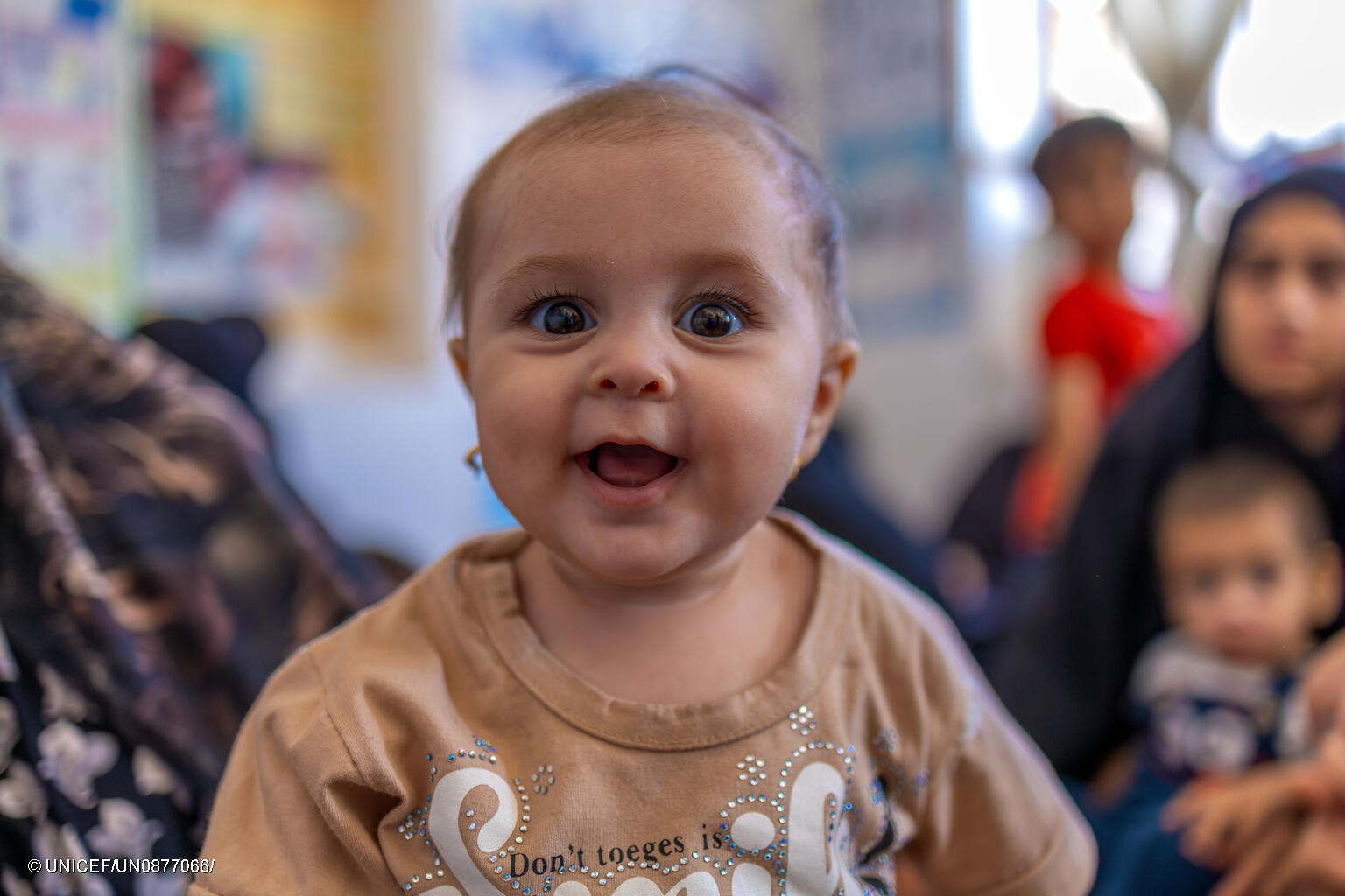 Ein Baby in Afghanistan lächelt glücklich in die Kamera.