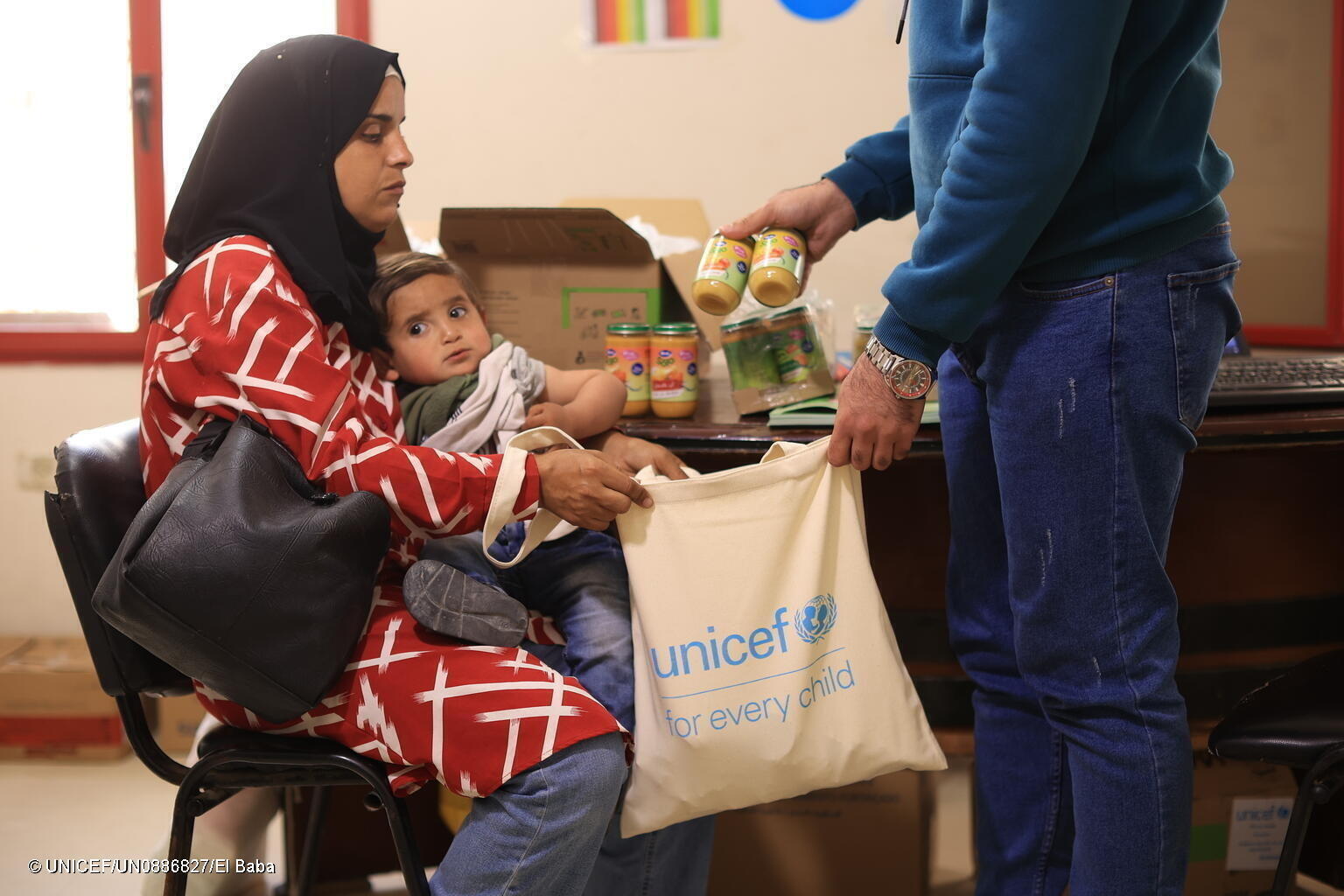 Im Gazastreifen bekommt eine Mutter Ernährungshilfe.