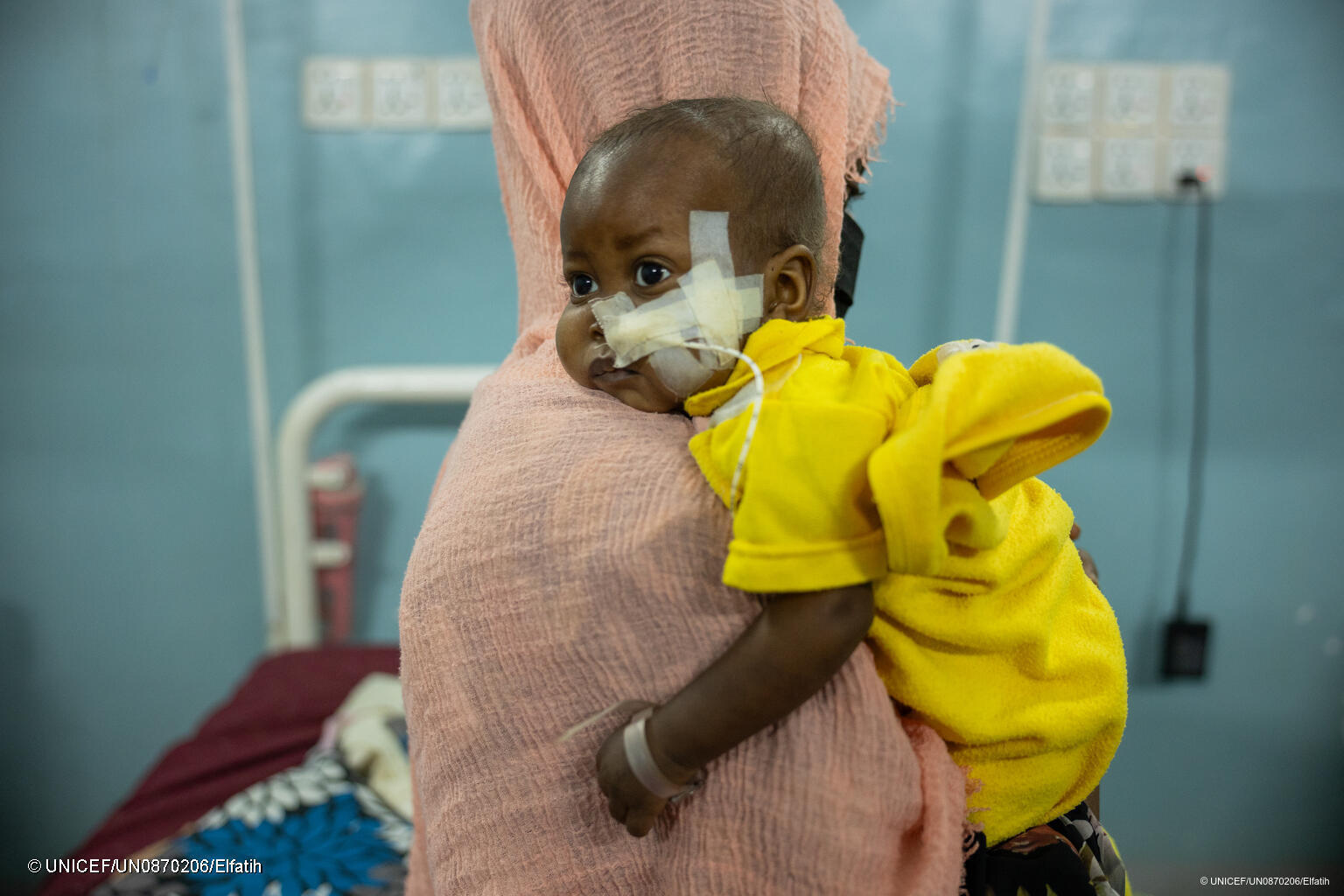 Ein verletztes Kind im Sudan in den Armen seiner Mutter.