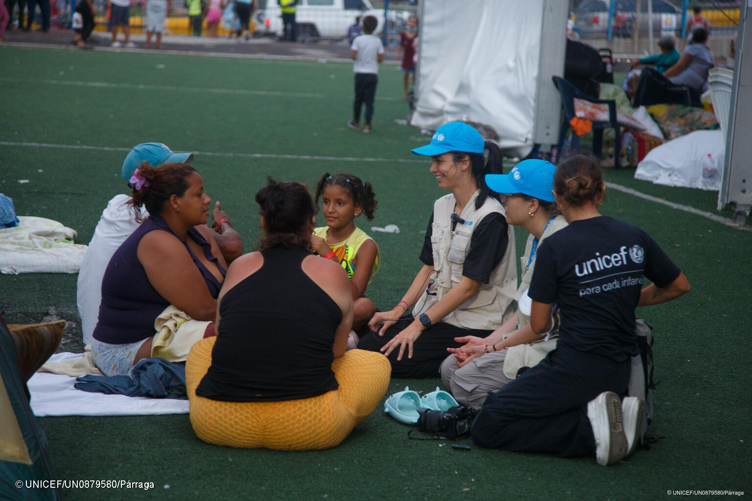 Eine UNICEF Mitarbeiterin spricht mit einer Familie in einer Notunterkunft in Venezuela.