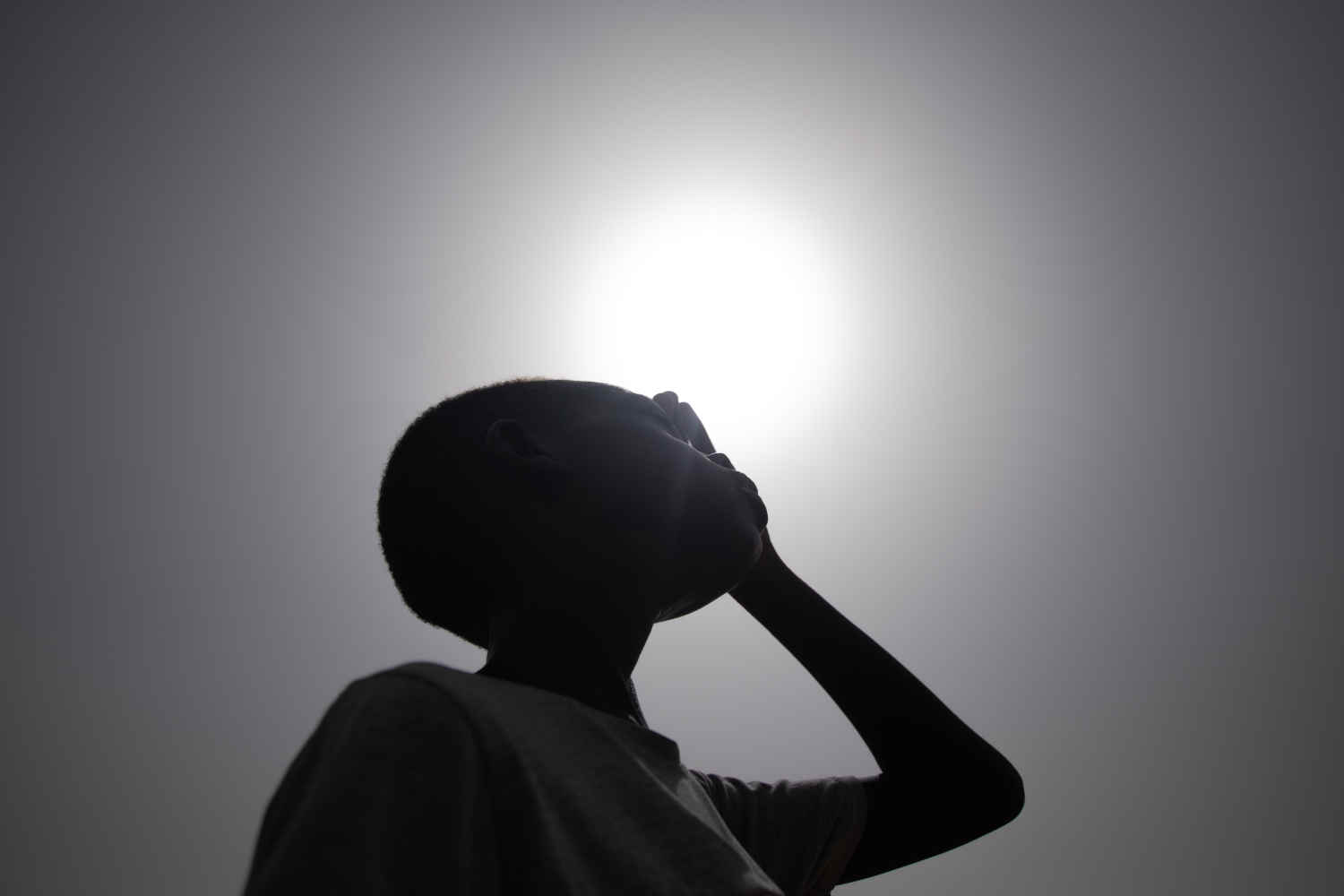 Junge schaut in die Sonne.