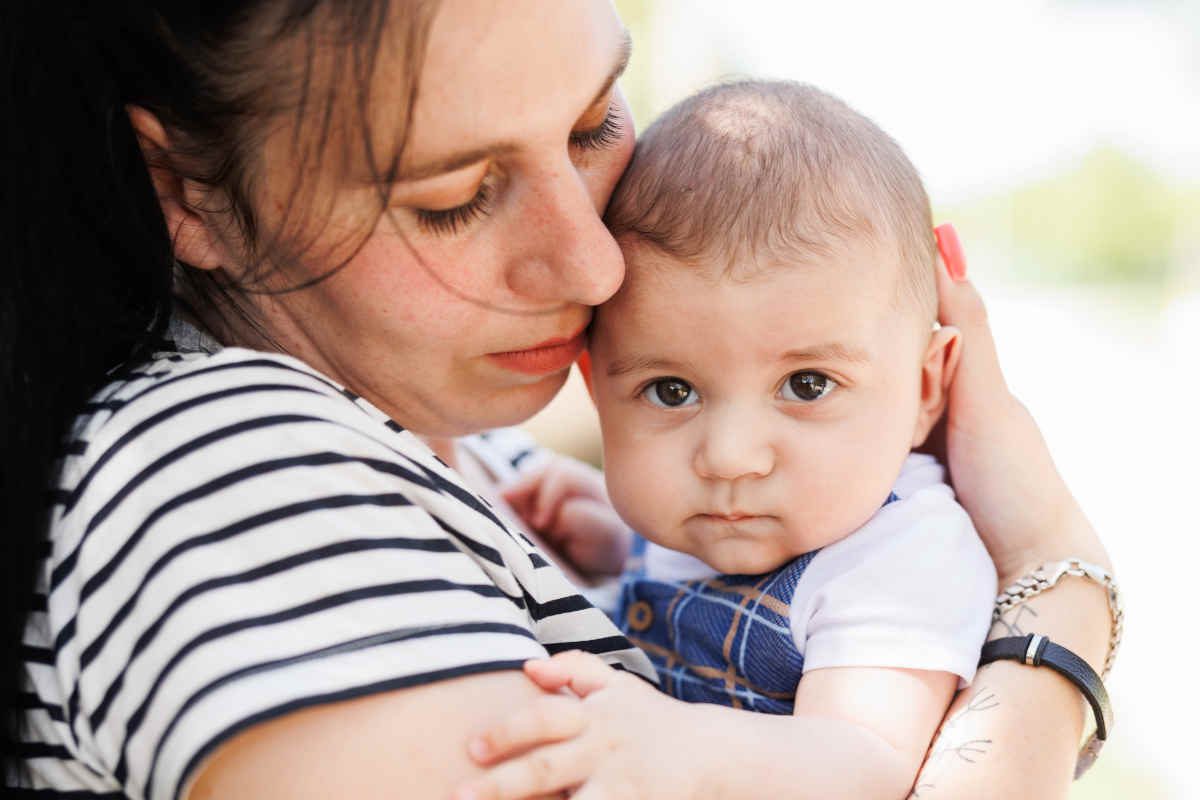 Mutter hält Baby liebevoll im Arm.