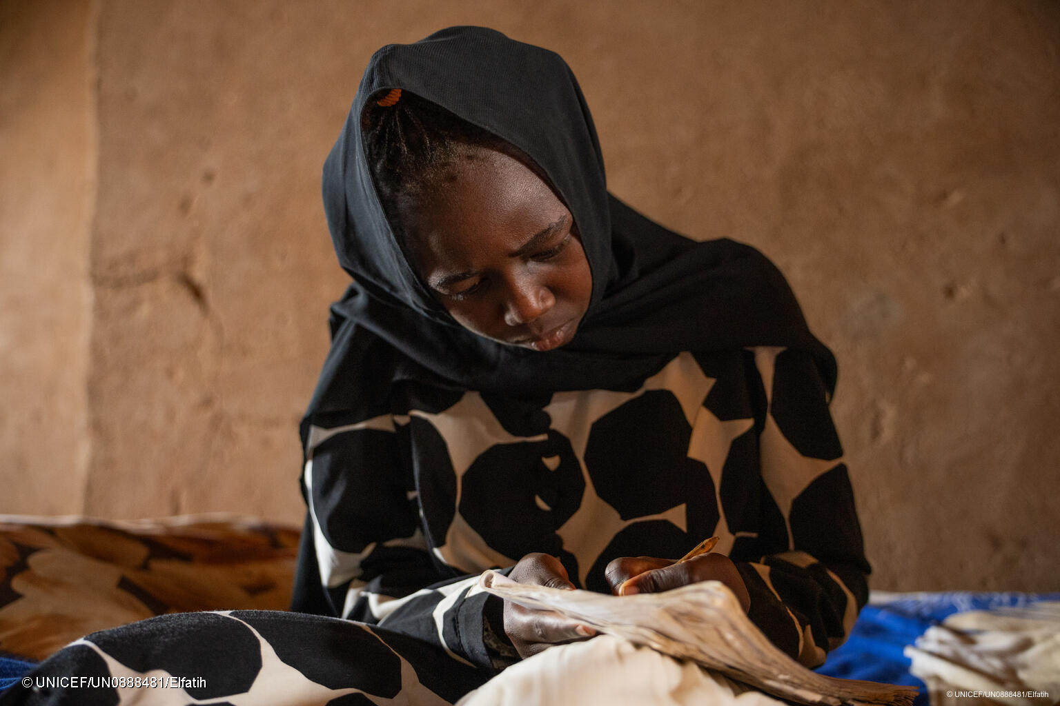 Ein Mädchen im Sudan schreibt in ihr Heft.
