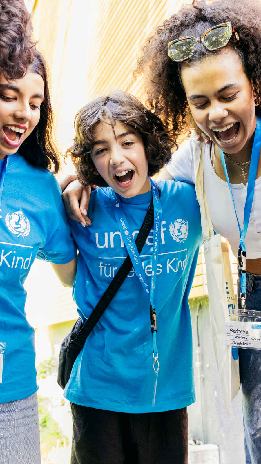 Kinder und Jugendliche mit UNICEF T-shirts stehen im Kreis.