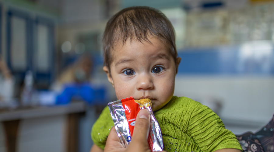 Mangelernährtes Kind in Afghanistan erhält Erdnusspaste.